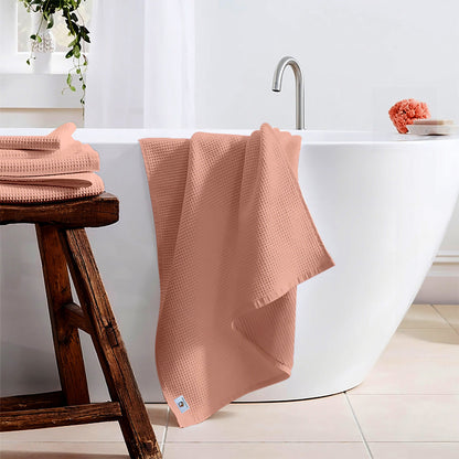 Pure cotton waffle bath towel in peach hanging in bathroom