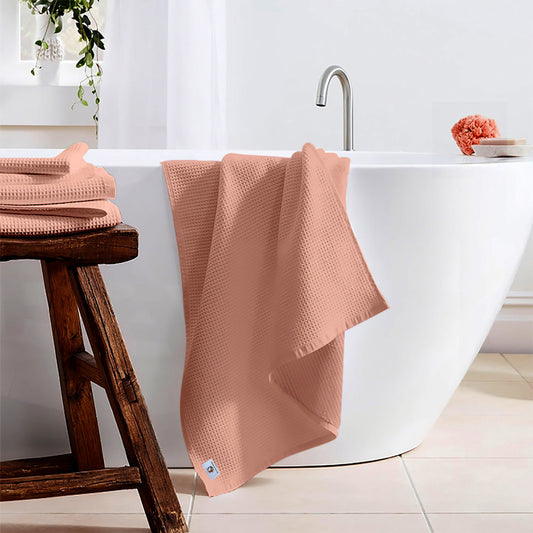 Pure cotton waffle bath towel in peach hanging in bathroom