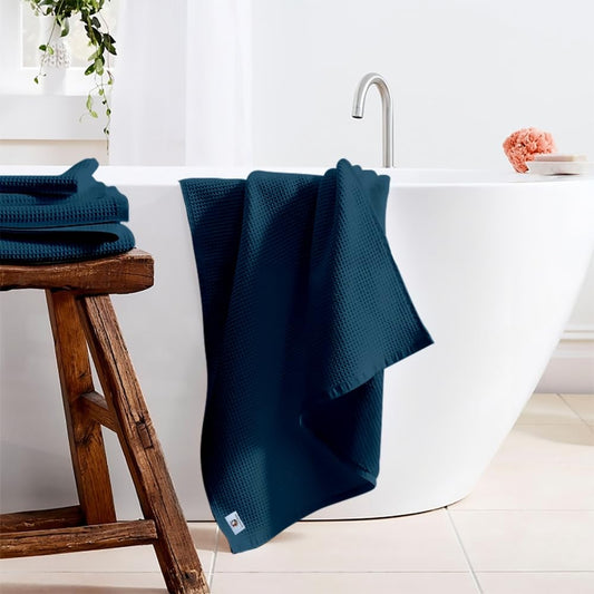 Pure cotton waffle bath towel in navy blue hanging in bathroom