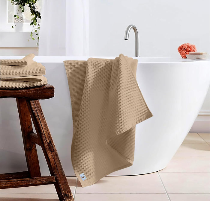 Pure cotton waffle bath towel in beige hanging in bathroom